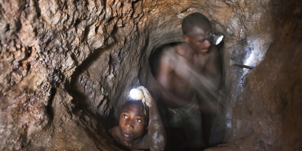 Alain Libondo 17 left and Nsinku Zihindula 25 hammering a rock to find cassiterite and coltan at Szibira South Kivu. Photo by Tom Stoddart via Getty Images